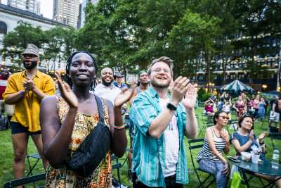 Audience members clap from the lawn at Bryant Park NYC for the Picnics Performances event featuring Mykal Kilgore, courtesy of Joe's Pub.