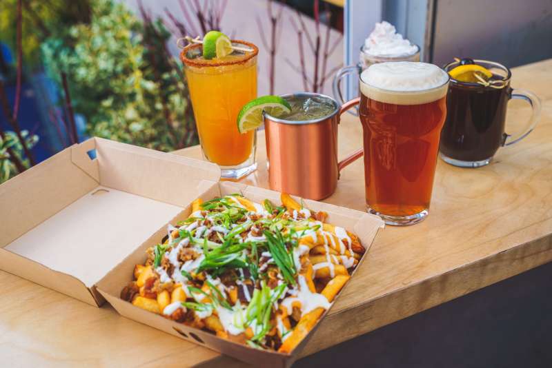 Nachos, beer, and winter drinks sit on a table overlooking the rink at Bank of America Winter Village at Bryant Park in New York City.