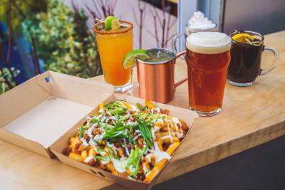 Nachos, beer, and winter drinks sit on a table overlooking the rink at Bank of America Winter Village at Bryant Park in New York City.