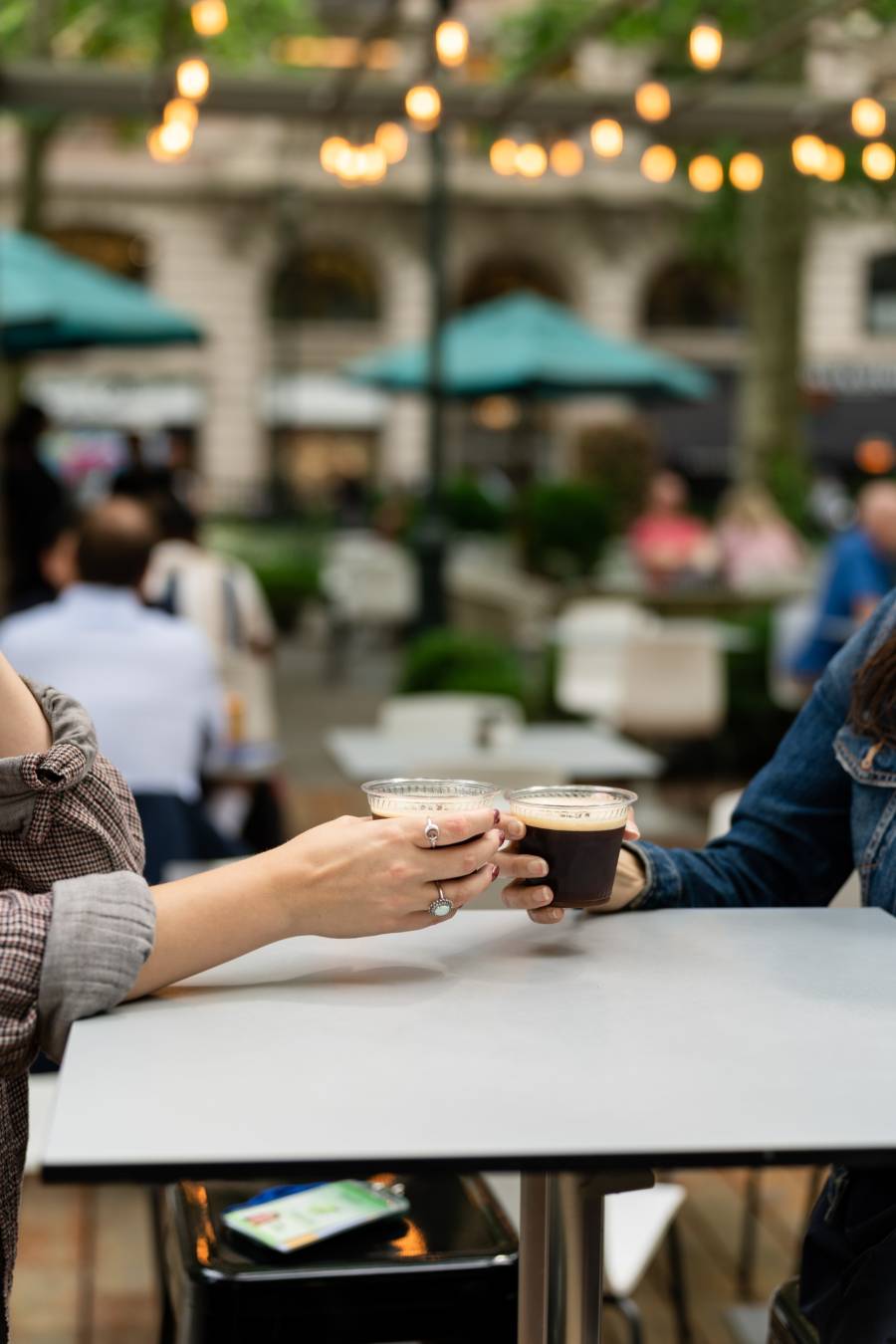 Two people toast with espresso martinis at Bryant Park's L'OR Porch in Midtown Manhattan.