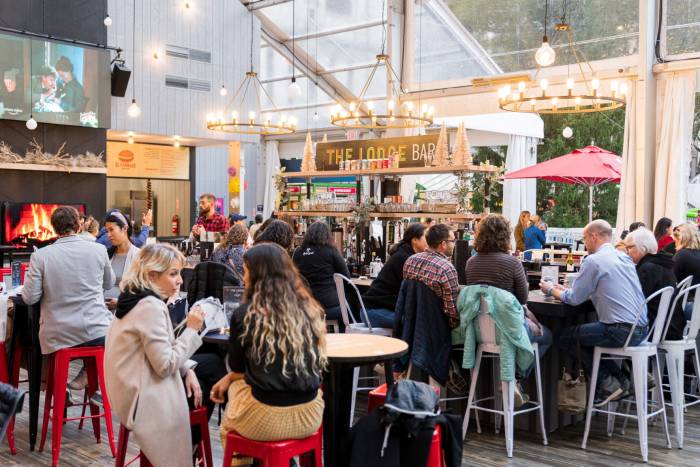 People sit at the Stout NYC bar in The Lodge at Bryant Park's Winter Village in New York City.
